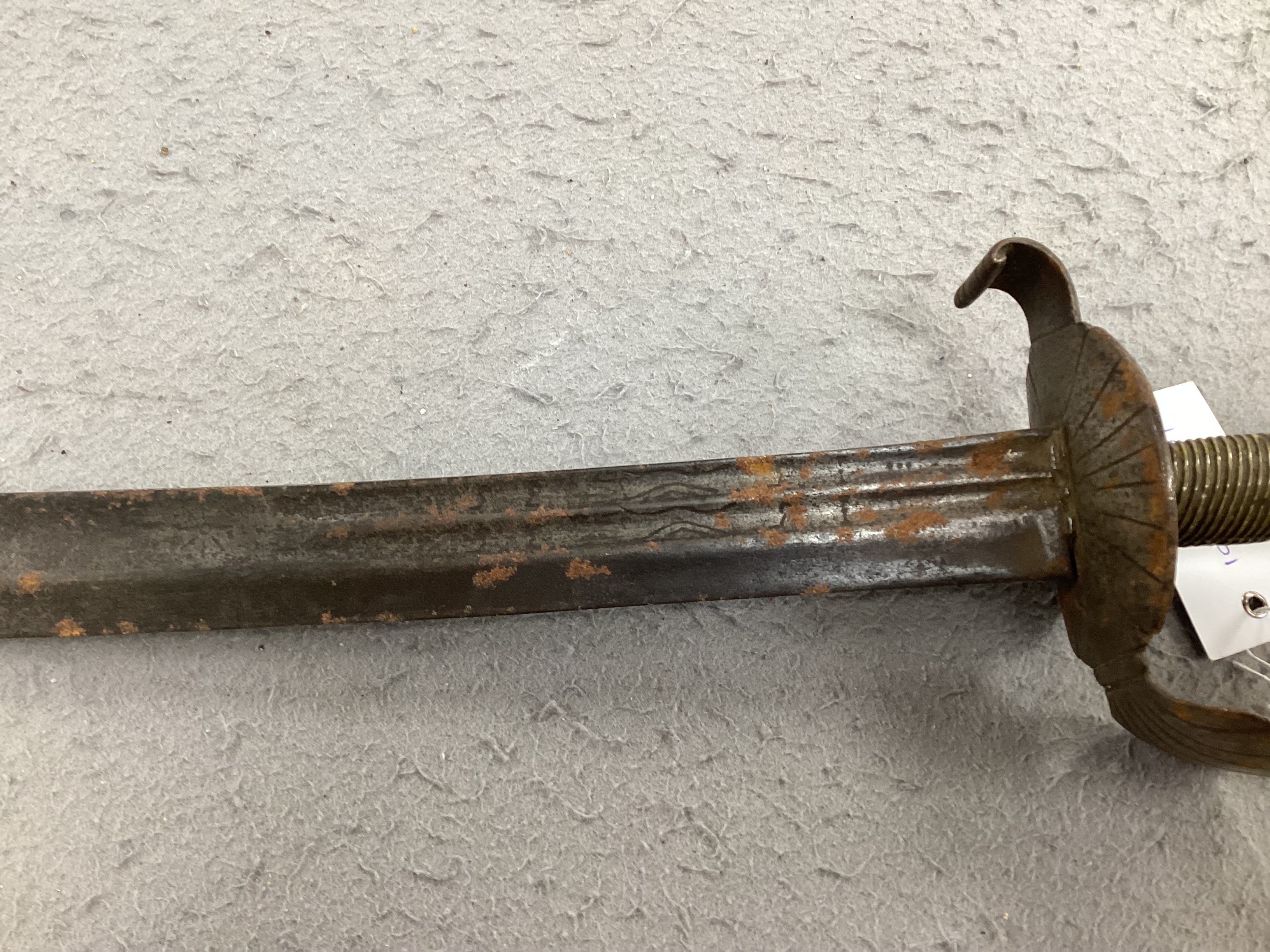 An English hangar, mid 17th century, curved fullered blade engraved with spurious date 1535 and running wolf mark, iron guard slightly reduced and swollen pommel, spirally carved and chequered bone grip, blade 67.5cm